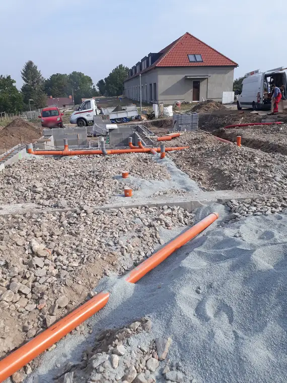 Ležatá kanalizace v základové desce novostavby před zásypem